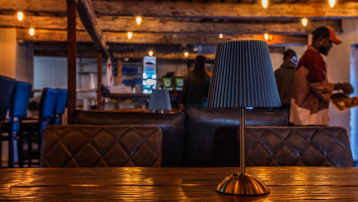 Baren med träbänk, lampskärm och lädersoffor i kvällsljus.